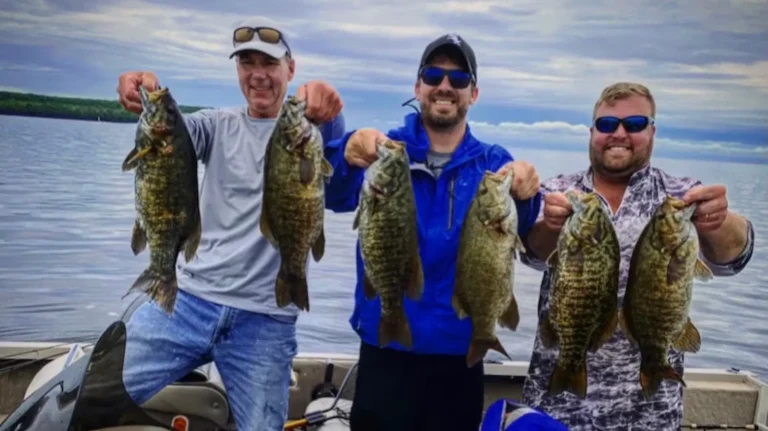 Three anglers holding smallmouth bass caught on Dale Hollow Lake, Tennessee