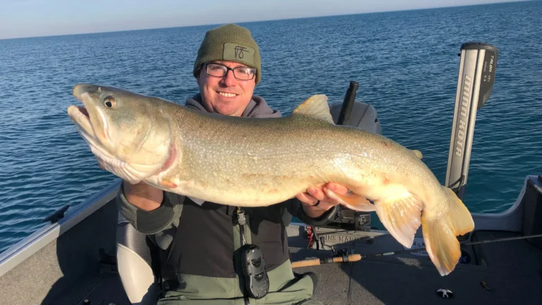 Angler holding a lake trout caught on Lake Michigan, a Great Lakes fishery impacted by invasive species